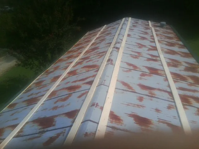 Rusted metal roof panels with new wood purlins before replacement — Storm Damage Roof Repair in Newton Highlands by Roofing Brothers