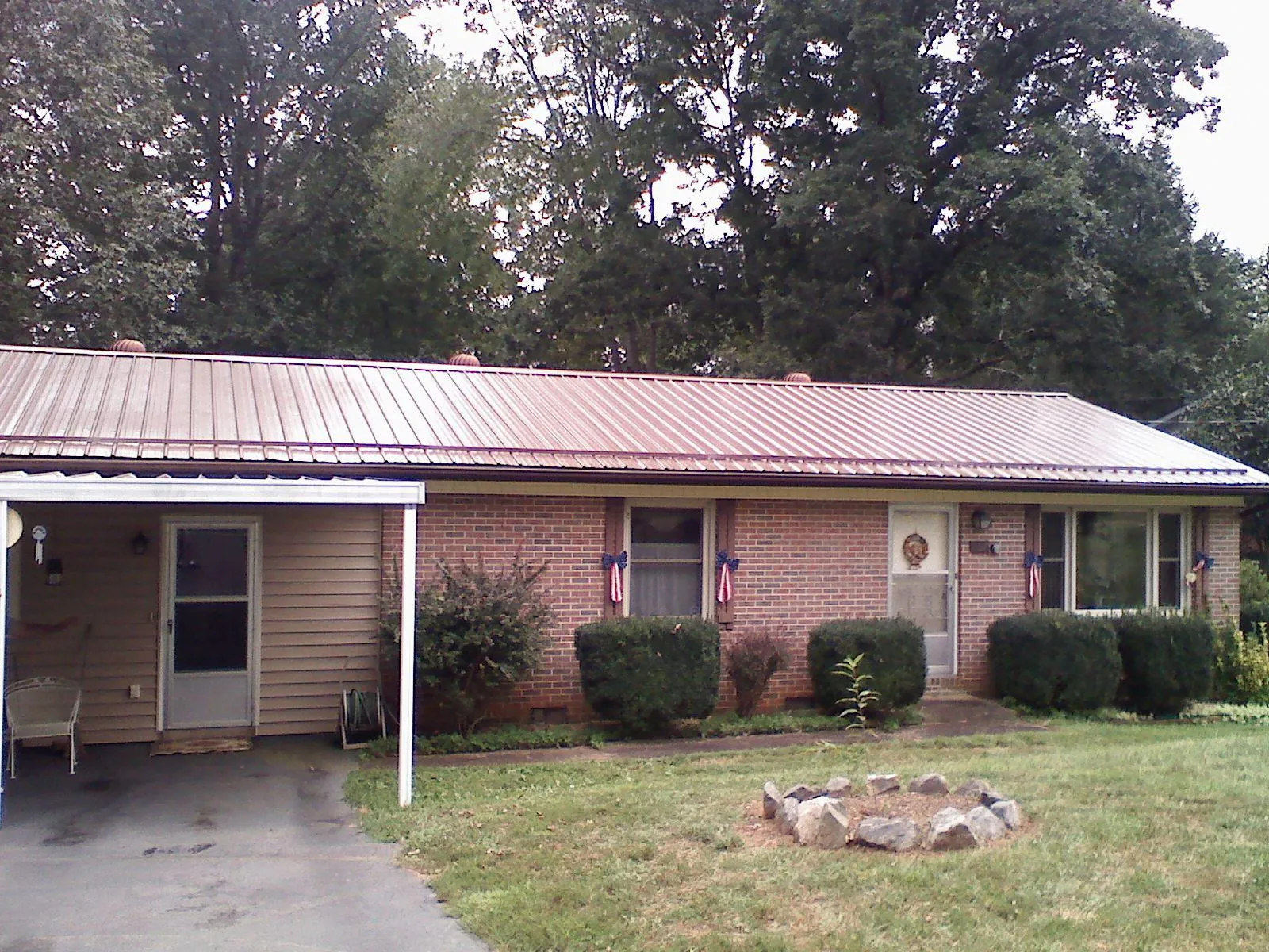 Bronze metal roof and carport on a brick ranch home — Roof Repair work by our crew in Newton Highlands